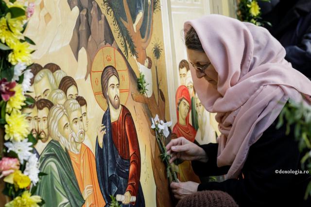 femeie cu flori la icoana Mantuitorului