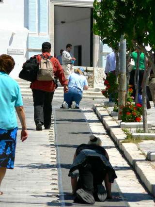 Pelerini urcând în genunchi scările din port până la biserica Maicii Domnului din Tinos