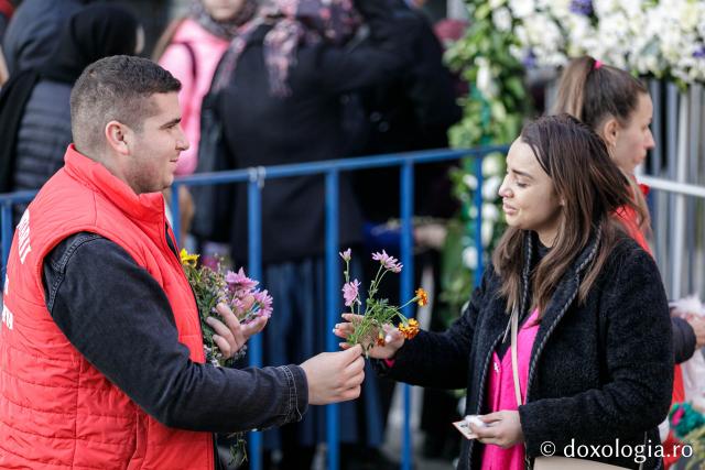 Voluntari împărțind flori pelerinilor