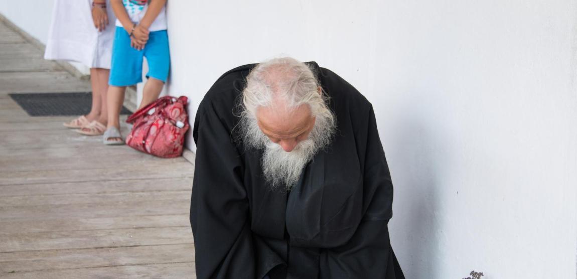 călugăr bătrân stând în genunchi