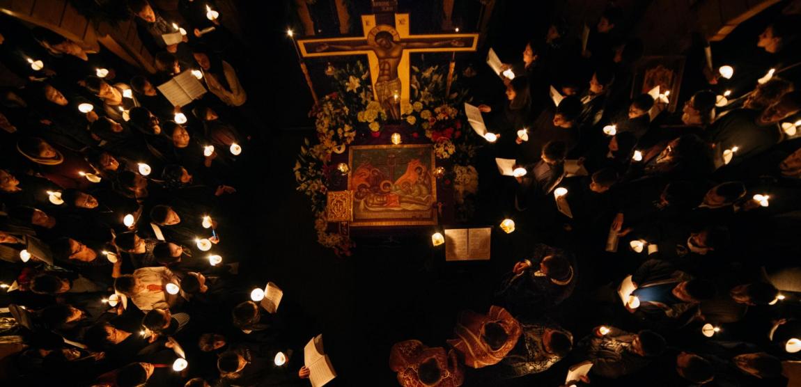 credincioși cu lumânări aprinse în mână