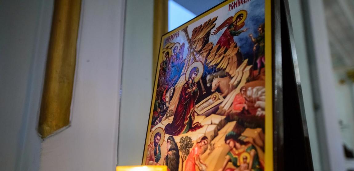 lumânare aprinsă la icoana Nașterii Domnului