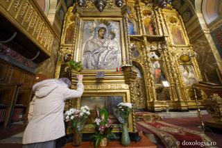 femeie în fața icoanei Maicii Domnului