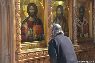 călugăr în fața icoanei Mântuitorului Hristos