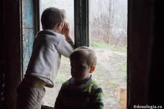 copil privind pe fereastră