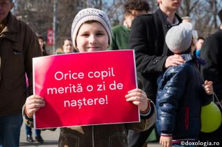 copil cu pancartă în mană