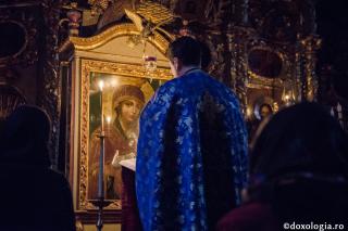preot în fața icoanei Maicii Domnului