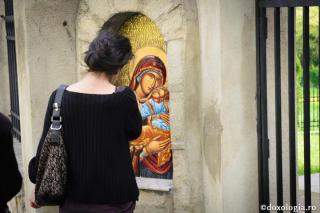 femeie în fața icoanei Maicii Domnului