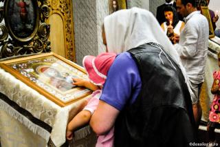 mamă și copil închinându-se la icoană