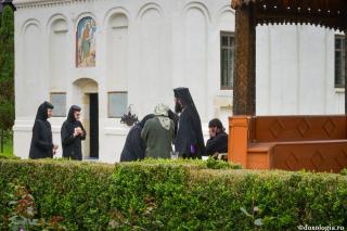 preot binecuvântând un grup de credincioși