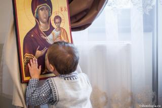 copil sărutând icoana Maicii Domnului