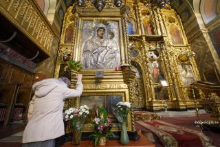 femeie în fața icoanei Maicii Domnului