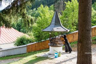 maică scoțând apă la fântână