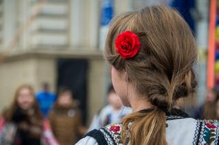 fată în costum popular cu floare roșie în păr