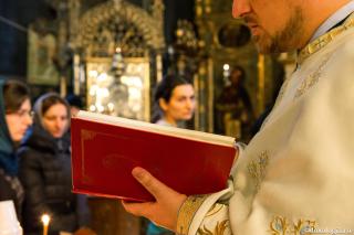 preot cu cartea în mână