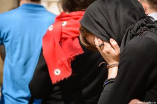 femeie îmbrăcată în negru cu fața în palmă