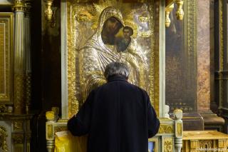 bărbat în fața icoanei Maicii Domnului
