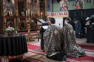preoți stând în genunchi în mijlocul bisericii