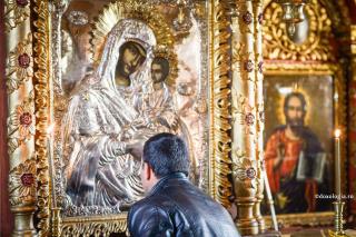bărbat în fața icoanei Maicii Domnului