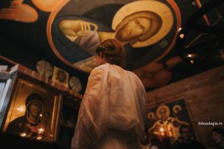 femeie în fața icoanei Maicii Domnului