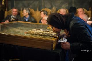 femeie sărutând Sfânta Evanghelie