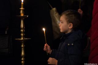 copil cu lumânare aprinsă în mână