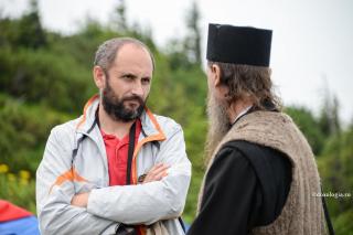 bărbat discutând cu un călugăr