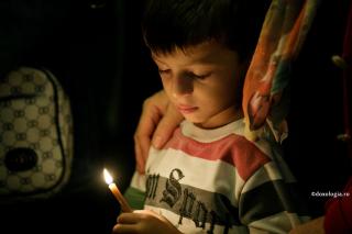 copil cu lumânare aprinsă în mână