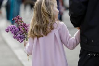 copilă cu flori de liliac în mână