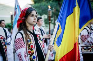 tânără în costum popular cu drapelul în mână