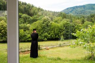 călugăr privind în curtea mănăstirii