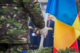 militar, ținând în mână un drapel