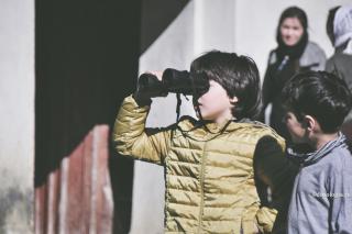 copil care se uita cu binoclul