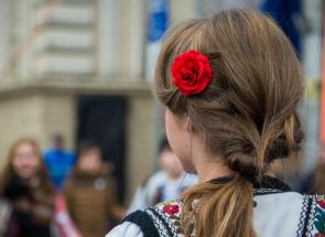 fată în costum popular cu floare roșie în păr