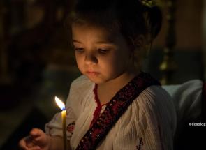 fetiță cu lumânare aprinsă în mână