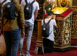 tânăr în genunchi în fața iconostasului
