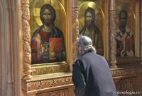 călugăr închinându-se la icoana Mântuitorului