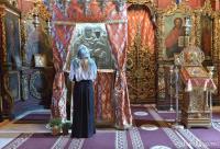 femeie în fața icoanei Sfintei Ana