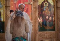 preot binecuvântând o femeie