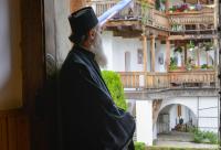 călugăr privind în curtea mănăstirii