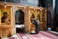 călugăr închinându-se la icoana Mântuitorului