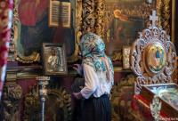 femeie în fața icoanei Mântuitorului Hristos