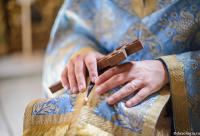 preot cu mâinile pe epitrahil pe capul credinciosului