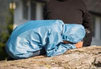 femeie în genunchi cu capul plecat