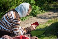 femeie cu carte de rugăciuni în mână