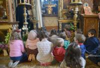 copii în genunchi în biserică