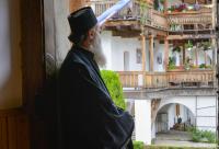 călugăr privind în curtea mănăstirii