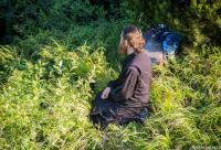 preot în genunchi în iarbă