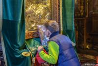 băiat închinându-se la icoana Maicii Domnului