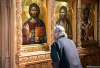călugăr închinându-se la icoana Mântuitorului